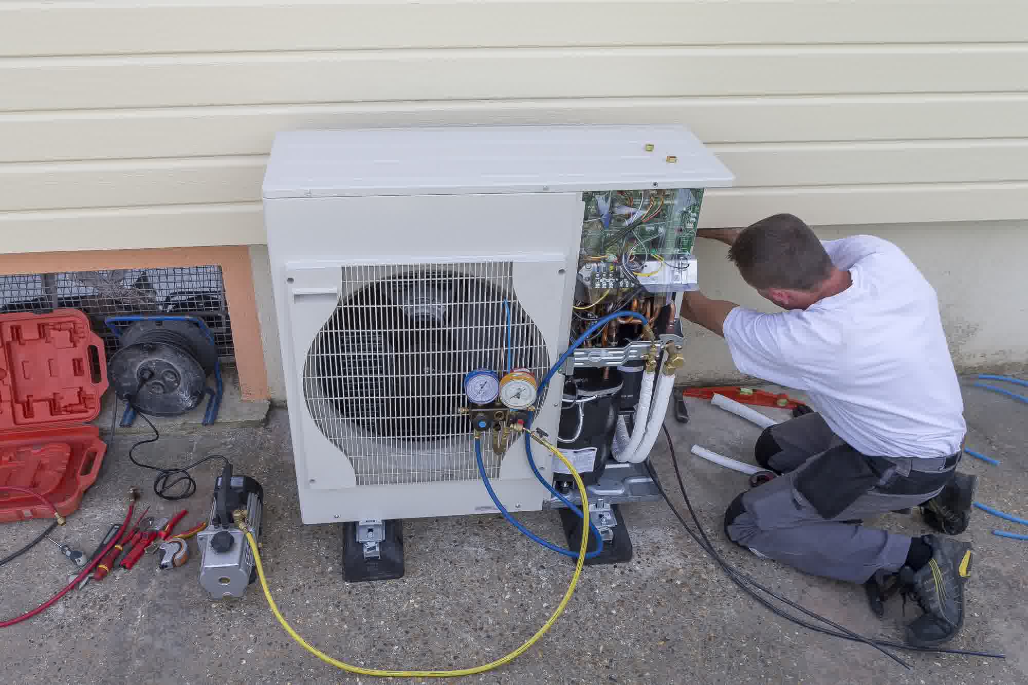 ambient cooling heating serverna Heat Pump Repair and Replacement A Step by Step Guide - Ambient Cooling & Heating A heat pump repairman fixing an outdoor heat pump with his tools.