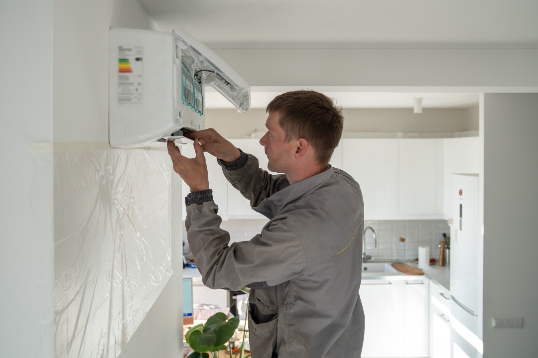 A skilled HVAC professional finishing up a mini split installation.
